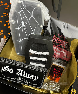 Halloween-themed gift set with decorative items on a matching background